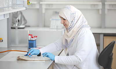 صورة لامرأة تقيم جهاز تعقيم في المختبر.